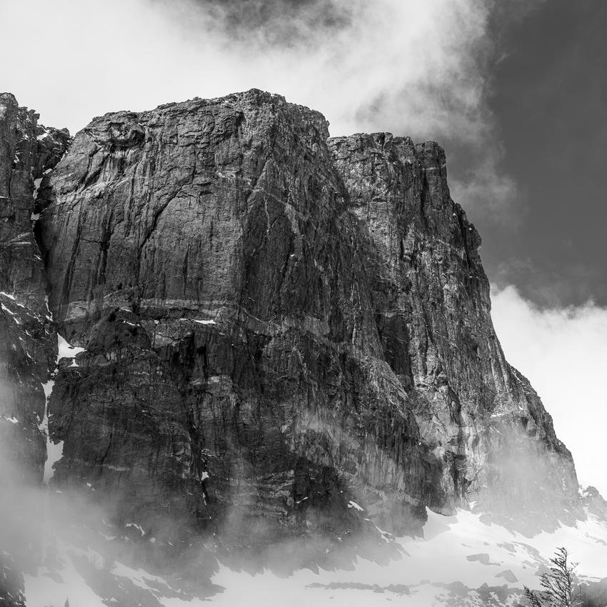 Hallett Peak seen from Emerald Lake. 70mm, f/11, 1/160s, ISO 100 Sheer rock face of a mountain peak partially shrouded in mist